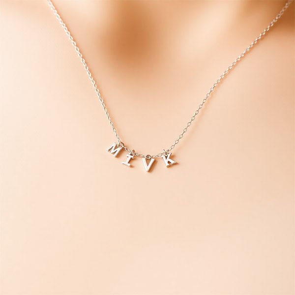 Minimalistische Silberkette - Eine elegante, schlichte Silberkette mit kleinen Buchstabenanhängern (1-2 mm).