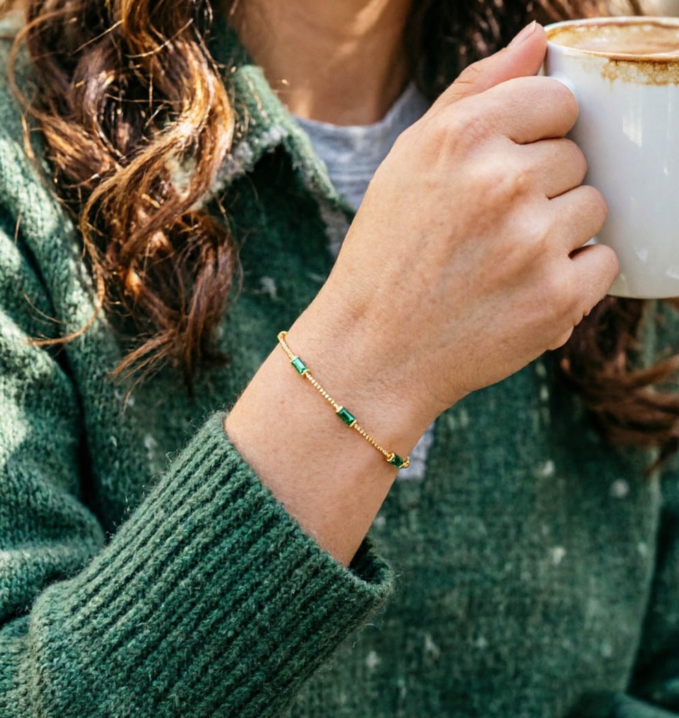 Frau trinkt Kaffee und trägt ein grünes Zirkonia-Armband aus 925er Sterlingsilber. Frau trinkt Kaffee und trägt ein grünes Zirkonia-Armband aus 925er Sterlingsilber.