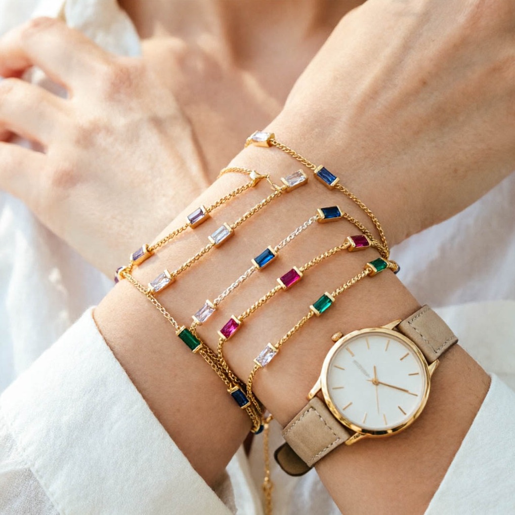 Zirkonia-Damenarmbänder in verschiedenen Farben Zirkonia-Armbänder in verschiedenen Farben am Handgelenk, kombiniert mit einer minimalistischen Uhr